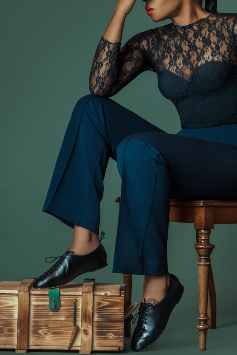 Spring shoe trends 2021. Elegant black woman sits down and is in thoughts.