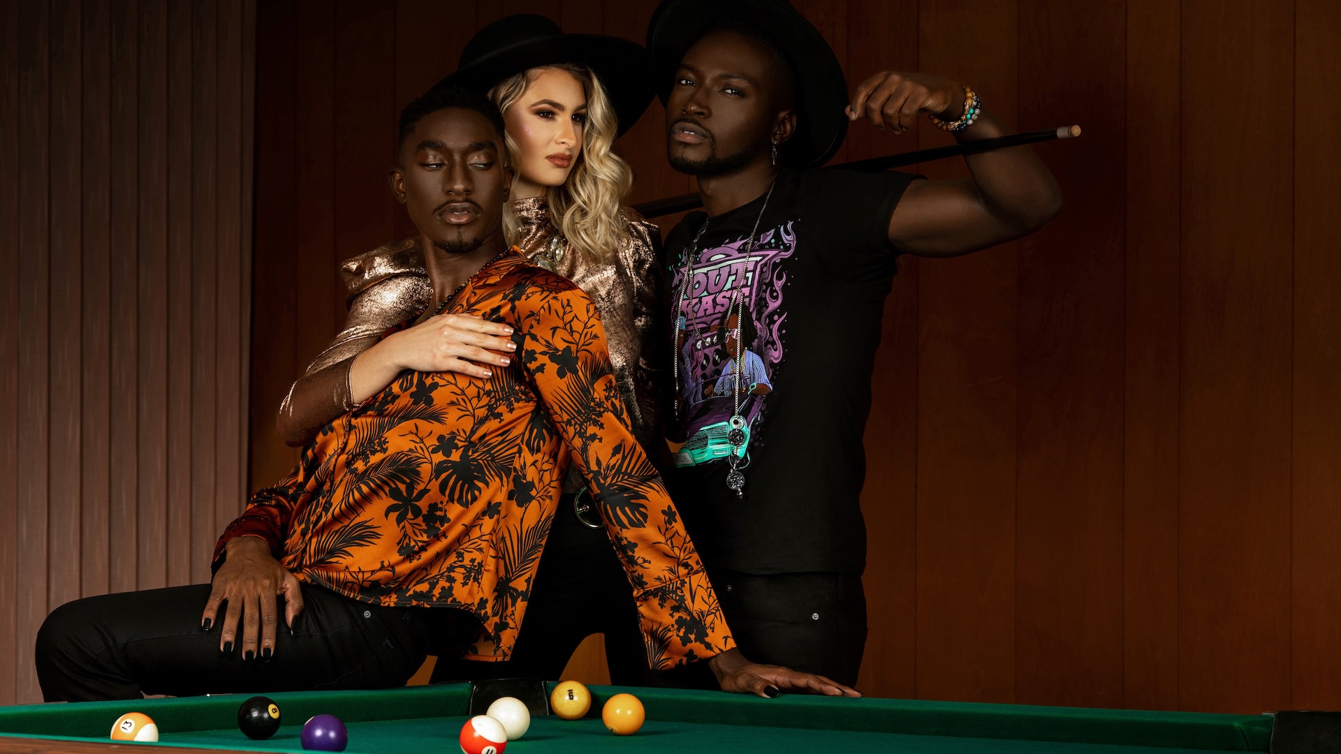 True Friendship. Portrait of a serene interracial group of three posing by themselves inside a pool billiards hall playing pool all of them wearing casual but stylish wardrobe and having a good time.