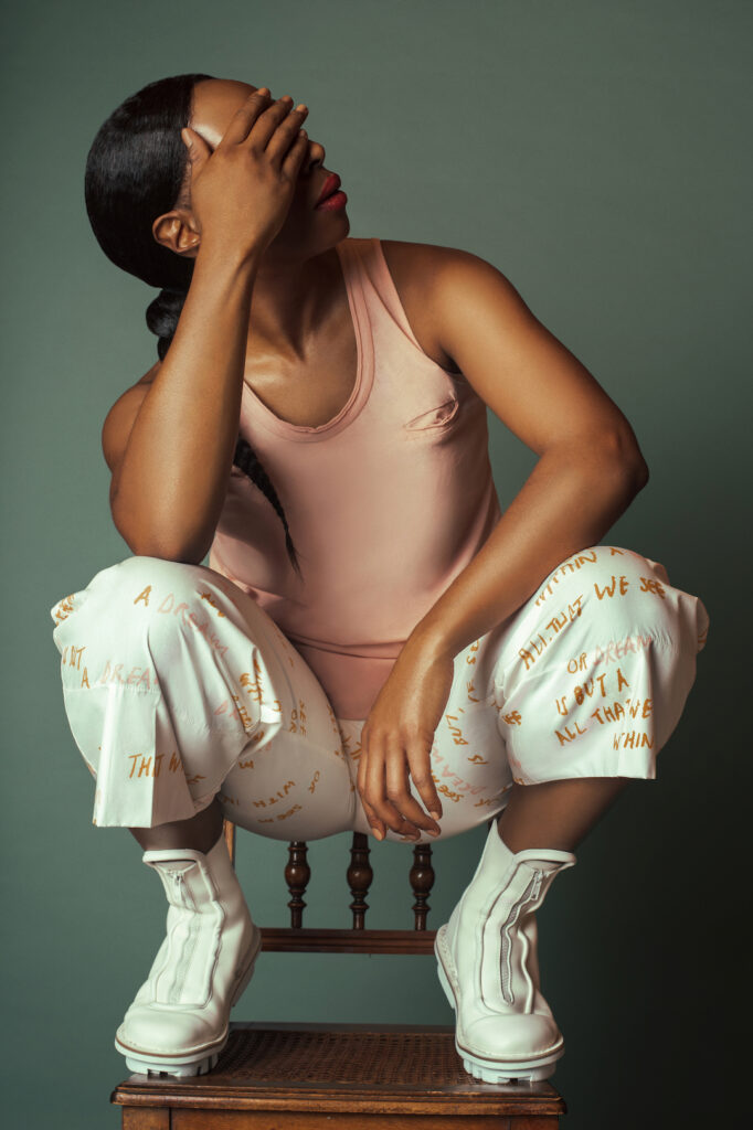 Spring boots for women. Black woman sitting on chair wearing white boots.