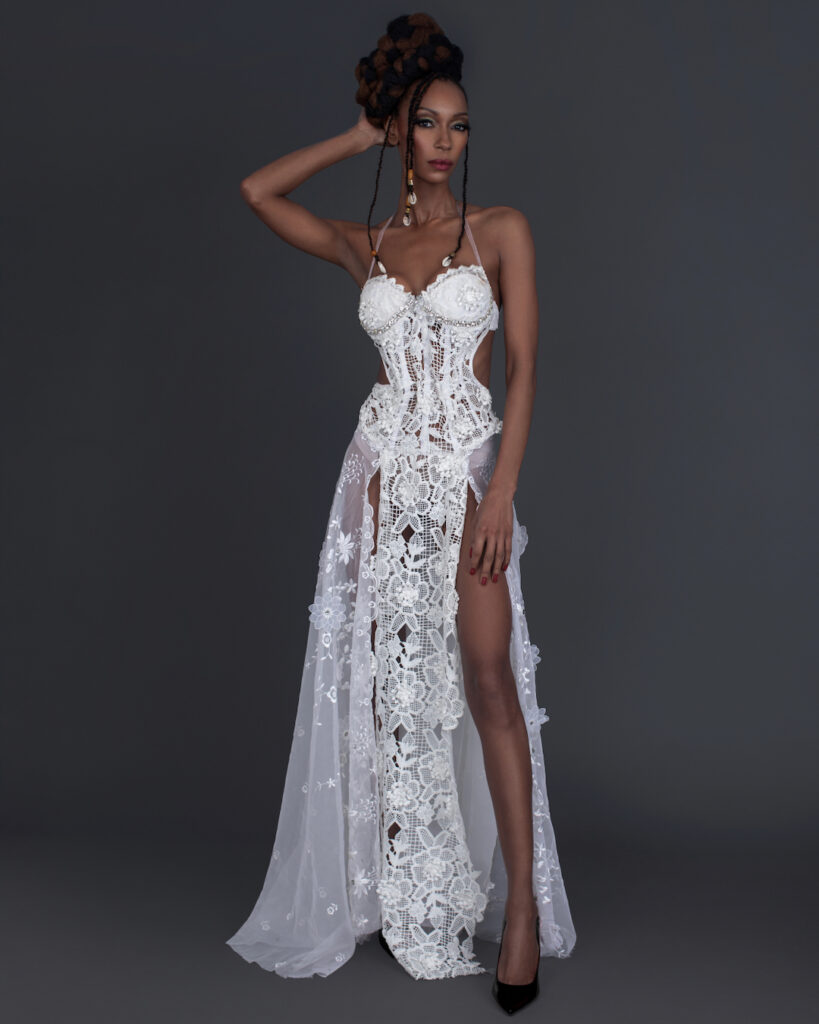 Work Ethic. Portrait of a sensual Black woman with Updo black hair and beautiful makeup standing by herself inside a studio with grey background wearing white summer dress with black high heel shoes.