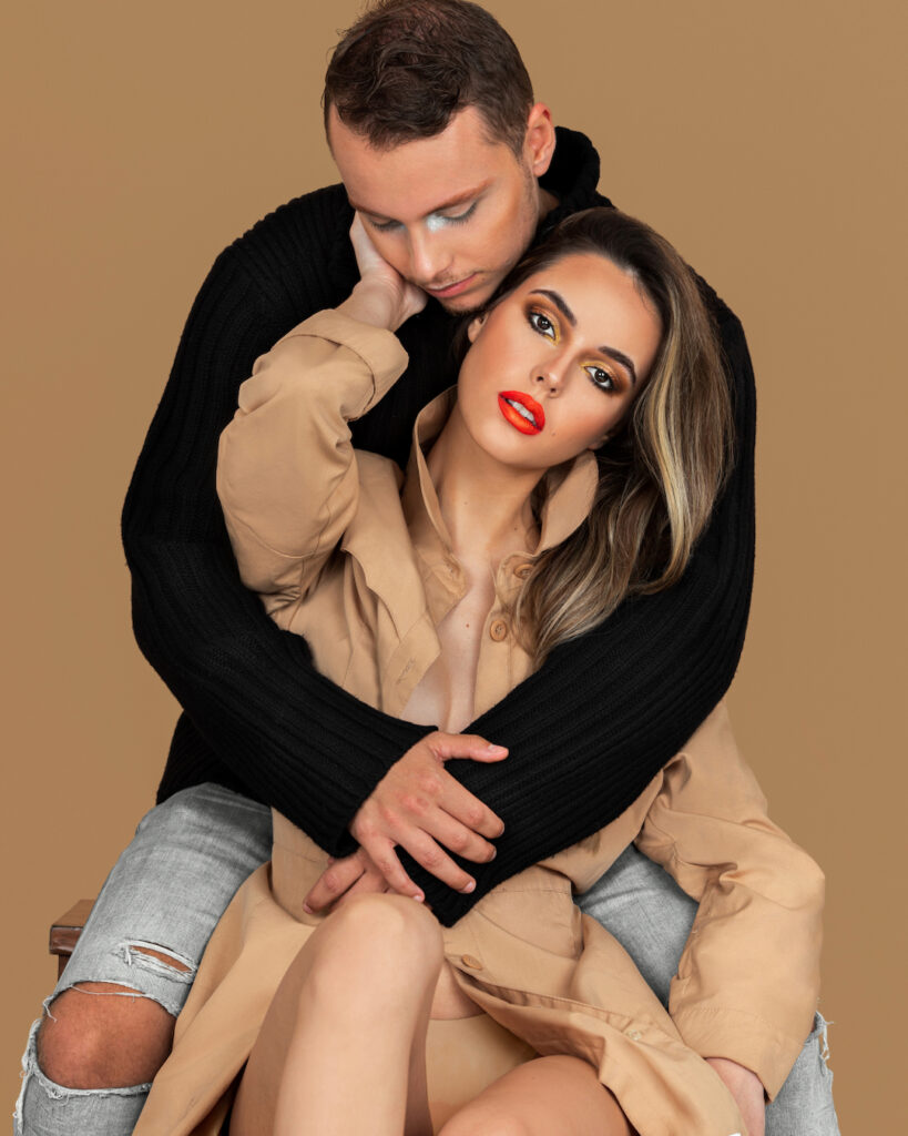 Modern beauty and self-expression. A couple is sitting arm in arm.