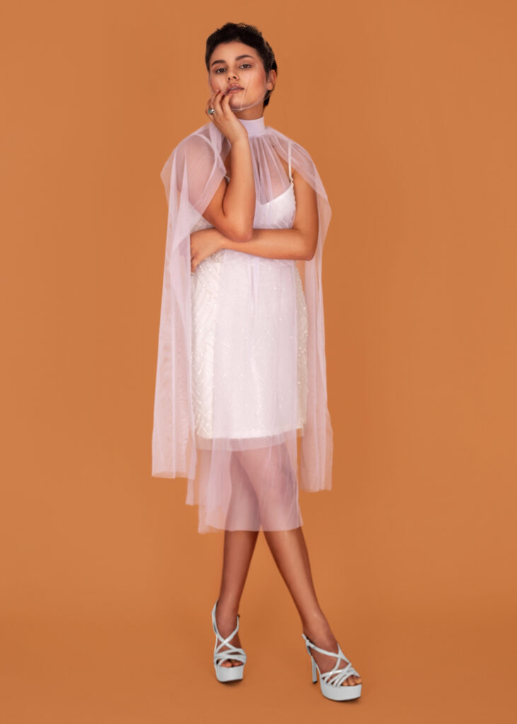 Latin model posing in white dress and heels – fashion magazine editorial.