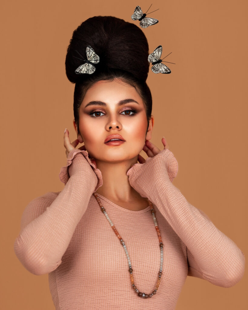 Latin model in pink rib cambria top surrounded by butterflies – fashion magazine editorial.