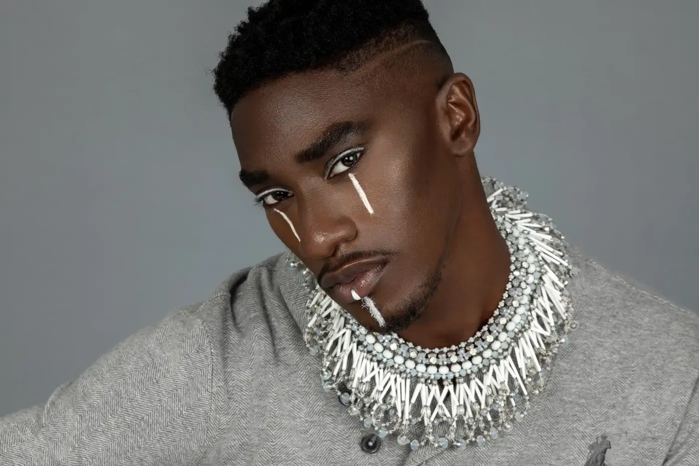 Close-up portrait with a grey tracksuit and layered jewelry