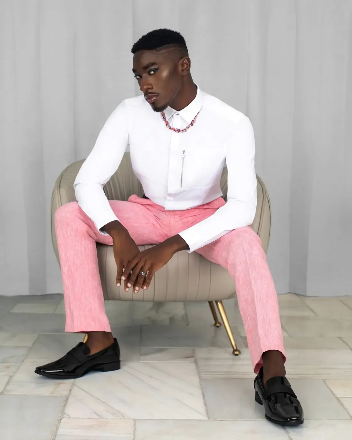 Black male model wearing pink trousers and a white shirt in the Pretty Boy Joy gender-fluid fashion editorial