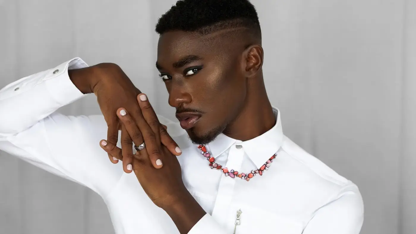 Beauty close-up of a Black male model in a white shirt and jewelry
