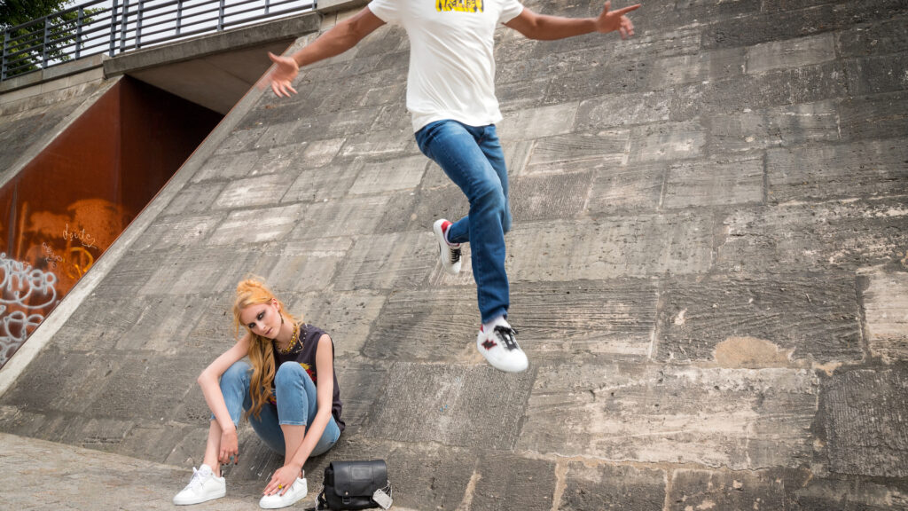 Young couple in front of concrete wall wearing Zadig & Voltaire wardrobe — Berlin fashion editorial.