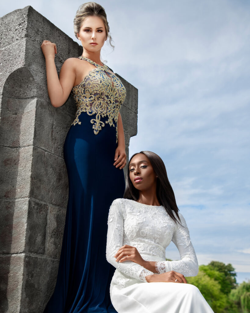 editorial wedding photography. Portrait of two confident women, one White and one Black, with elegant makeup, posing on a bridge in high heels and wedding dresses.