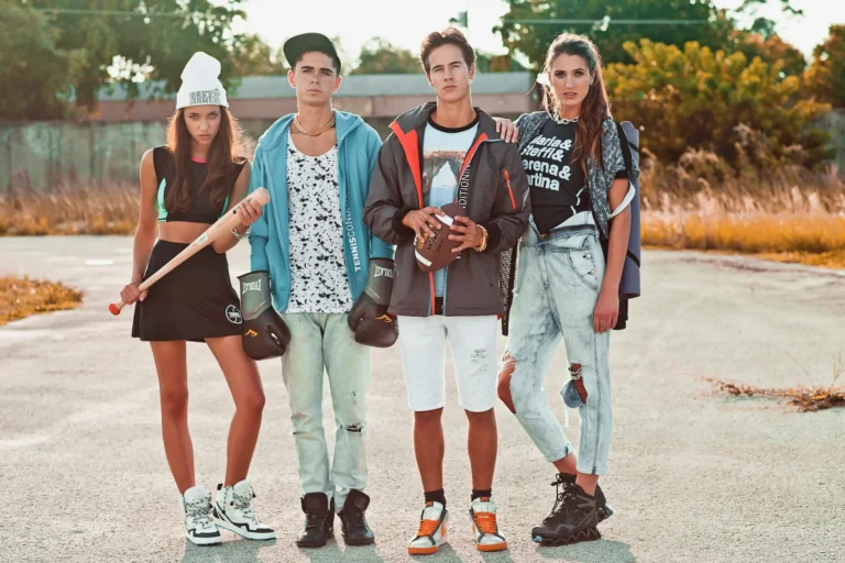 Four models in sport-inspired Miami streetwear posing outdoors in warm afternoon light