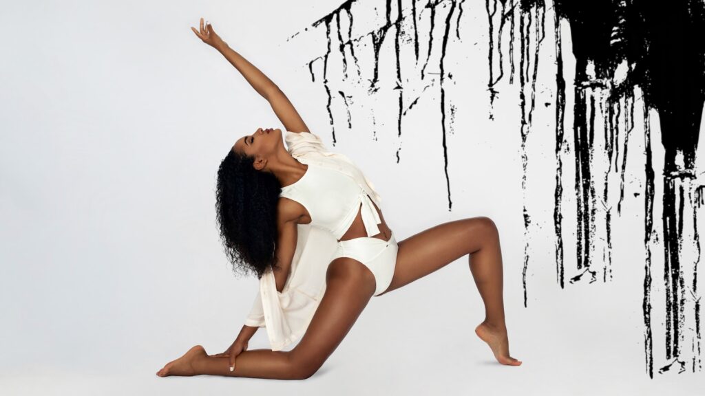 modeling photoshoot elegant Latin woman in beige swimsuit kneeling with long curly black hair