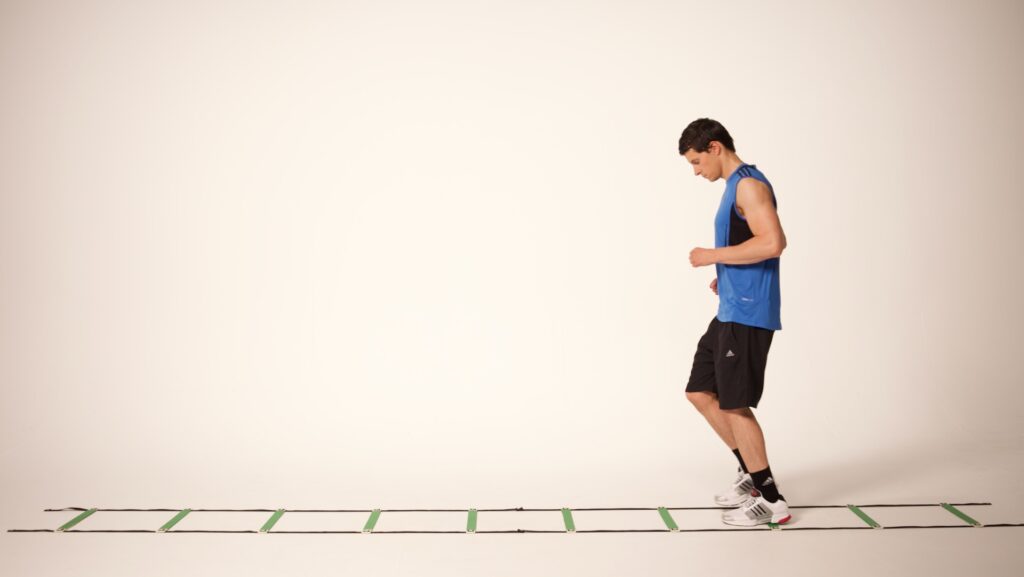 Tennis player performing lateral speed ladder drills to improve agility and coordination.
