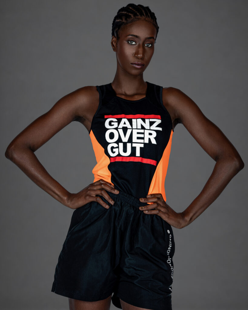 Gigi posing with arms raised in a contemporary athletic fashion editorial