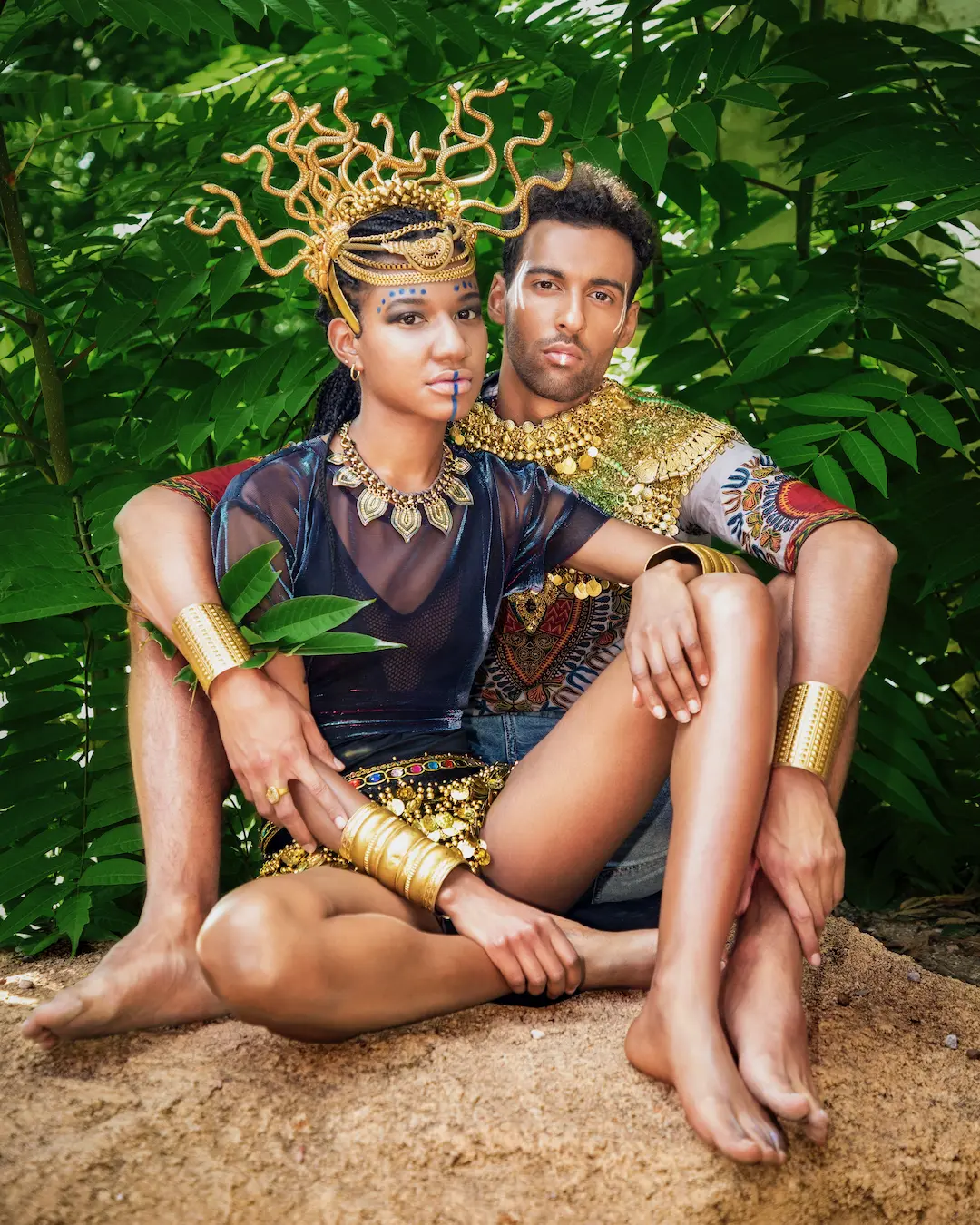 Two models seated closely in coordinated African-inspired fashion