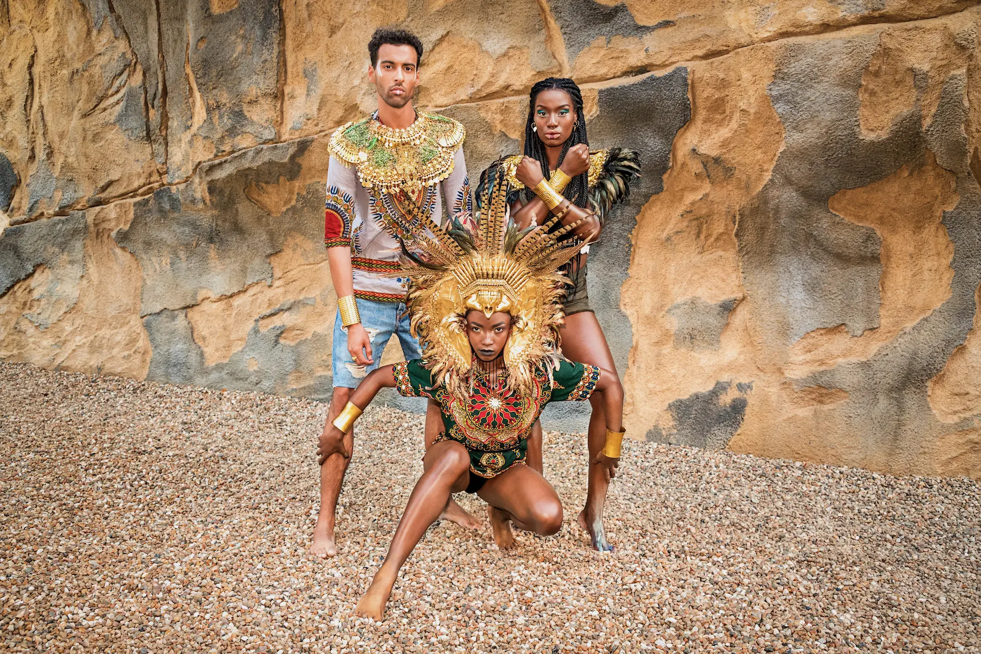 Three models posed together against a textured stone wall