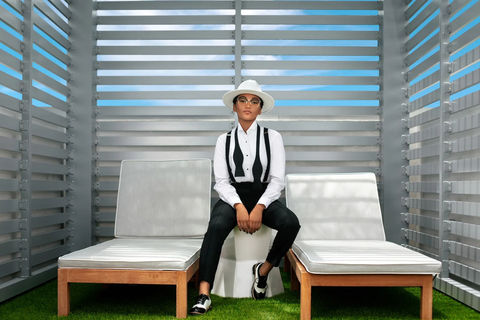 Jordan Kristine Seamon in white shirt, suspenders and hat inside a Hilton Aventura cabana
