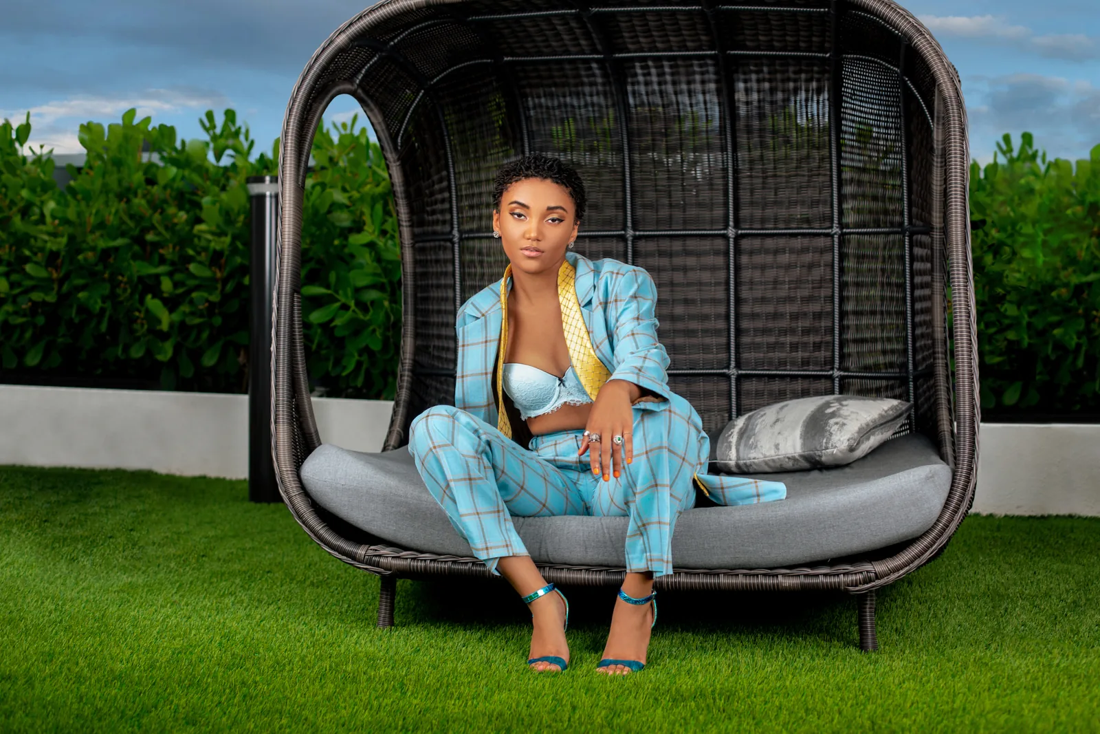 Jordan Kristine Seamon in a turquoise striped suit on a poolside lounger