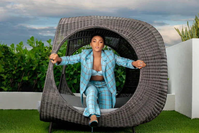 Jordan Kristine Seamon in a turquoise suit framed by a circular cabana chair