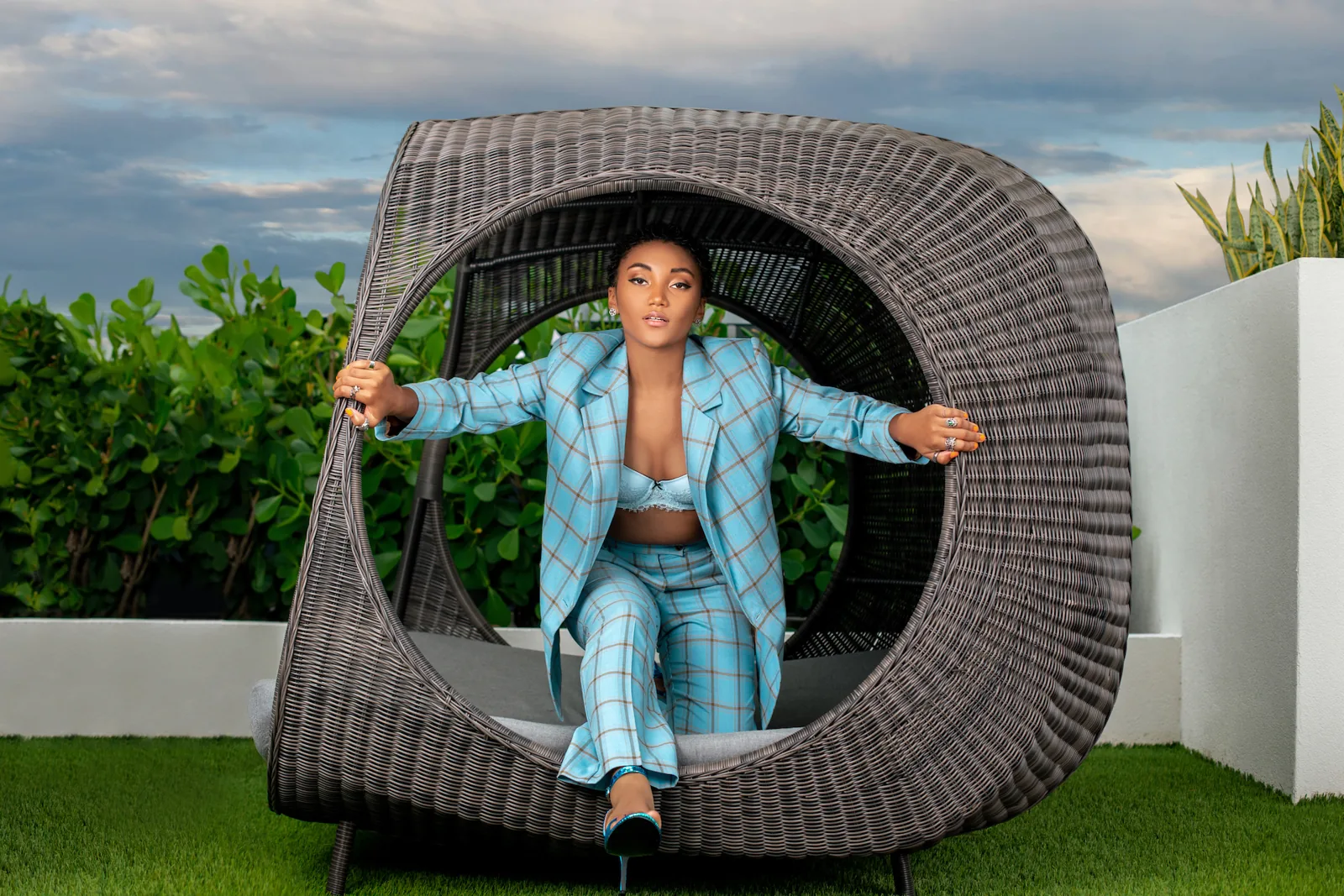Jordan Kristine Seamon in a turquoise suit framed by a circular cabana chair