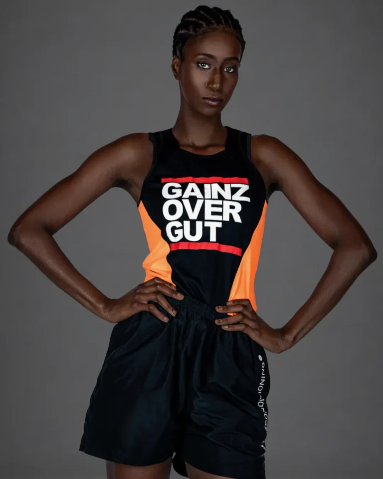 Gigi posing with arms raised in a contemporary athletic fashion editorial