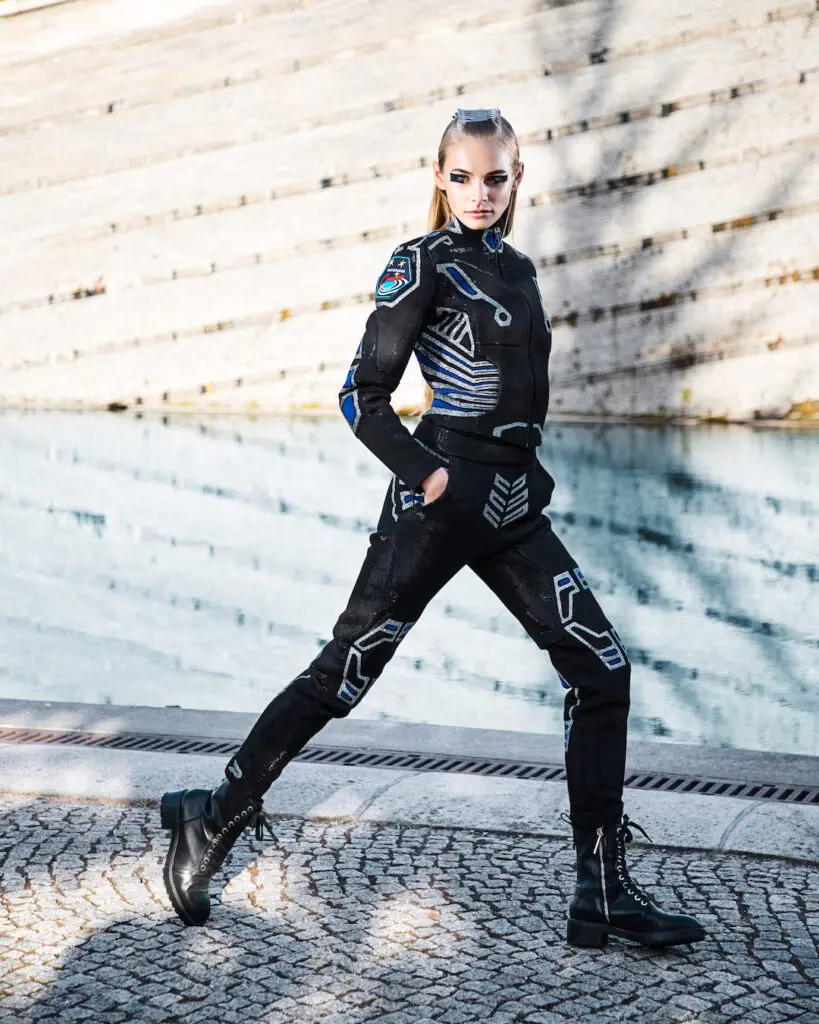 White woman wearing a black bodysuit and over-the-knee leather boots