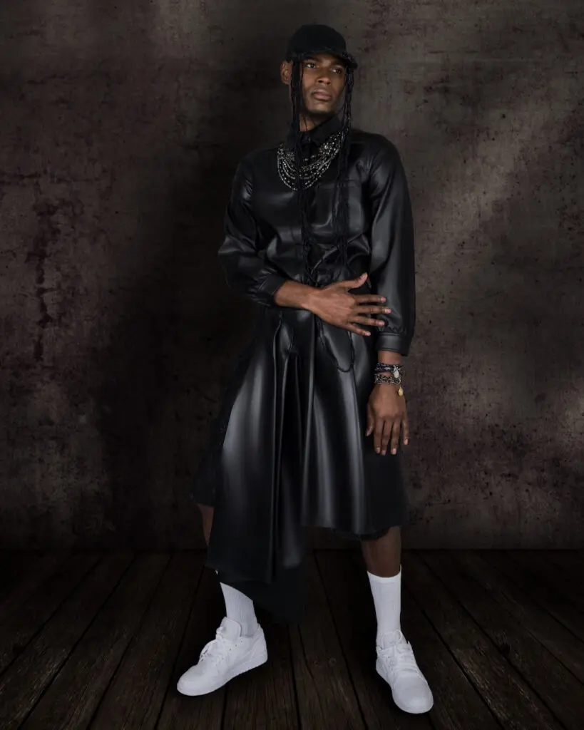 Avant-garde fashion editorial portrait of a Black male model wearing silver jewelry and white sneakers