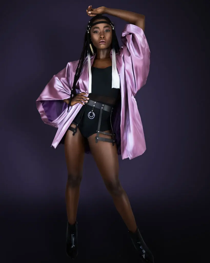 Black woman in a purple kimono, black bodysuit and wide leather belt