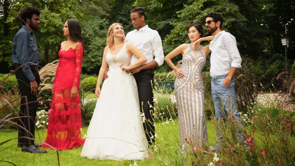Three couples in bridal fashion photographed in a garden