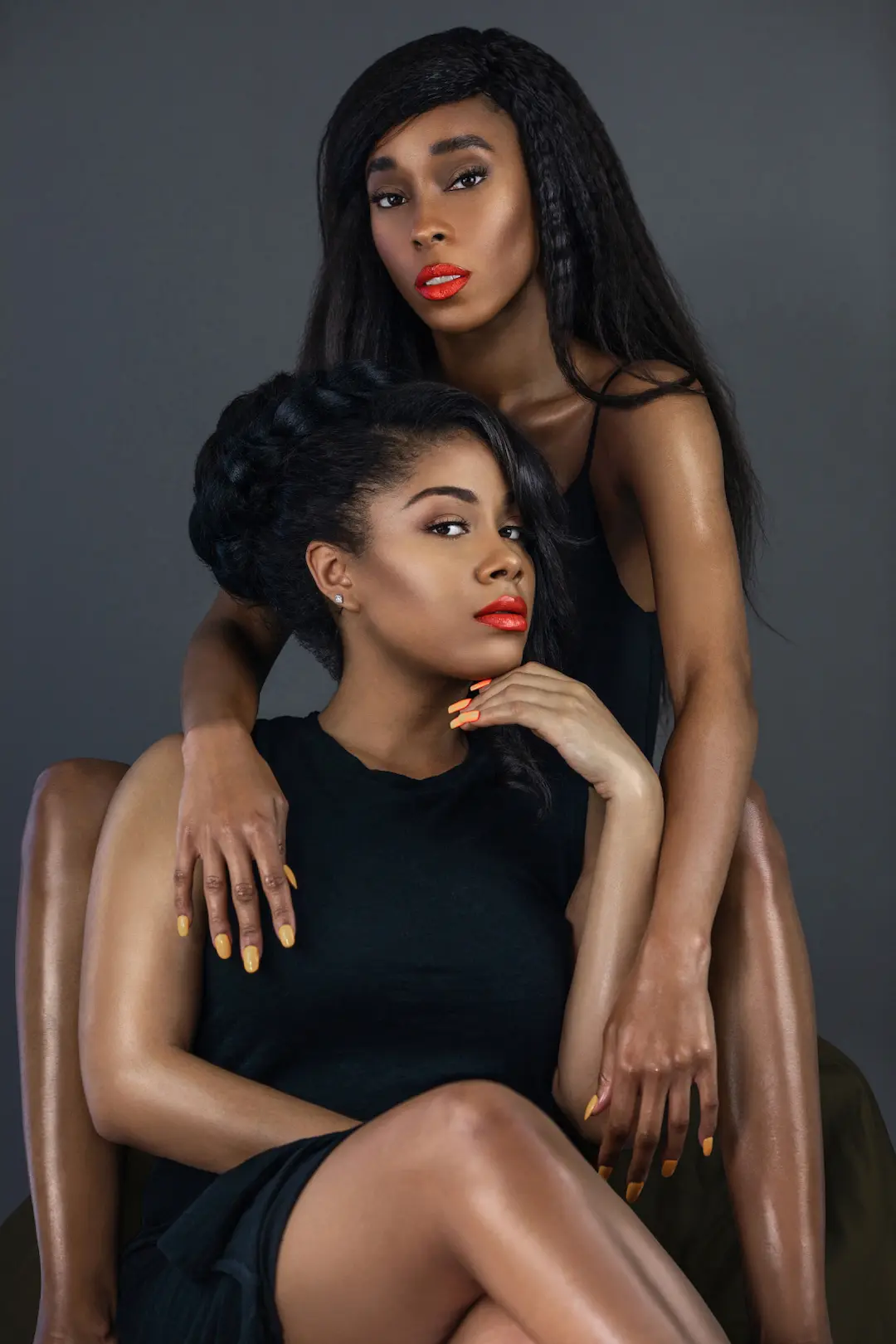 Two models wearing black dresses in an elegant studio fashion editorial