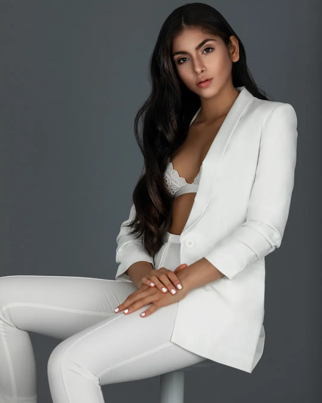 White tailored suit styled with tonal lingerie in a studio editorial