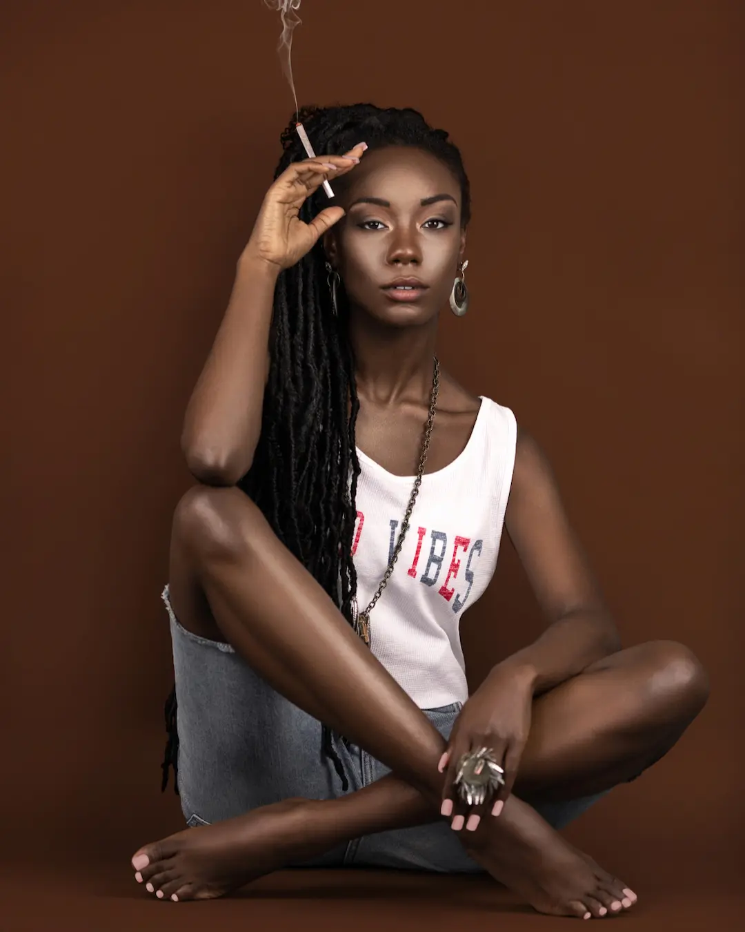 Ann-neika Jean Charles seated in a relaxed bohemian outfit with long locs