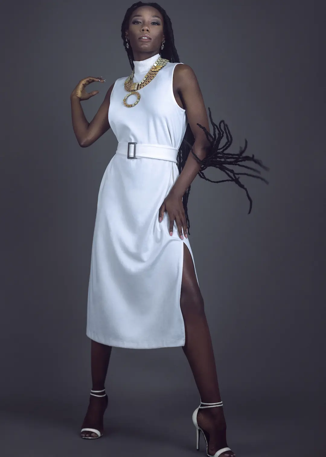 Ann-neika Jean Charles wearing a white dress and heels with long locs in the studio
