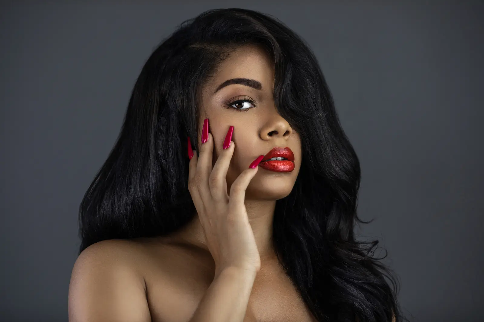 Minimalist beauty styling with dark waves and polished red lipstick