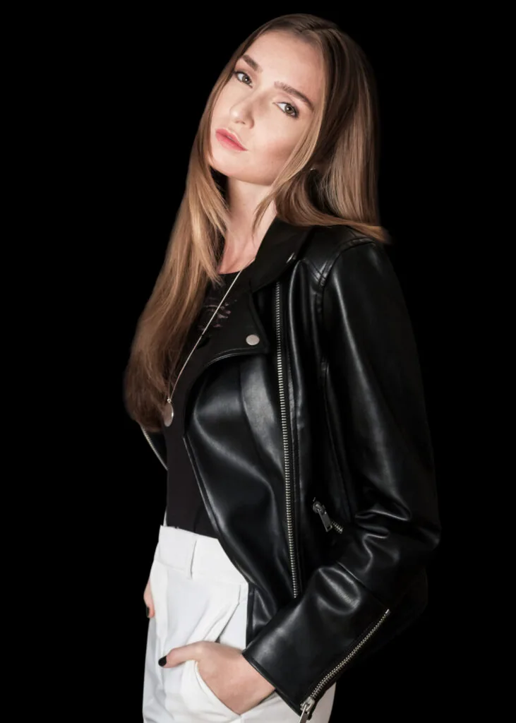 Model in a black leather jacket against a dark background, photographed by Phil Halfmann