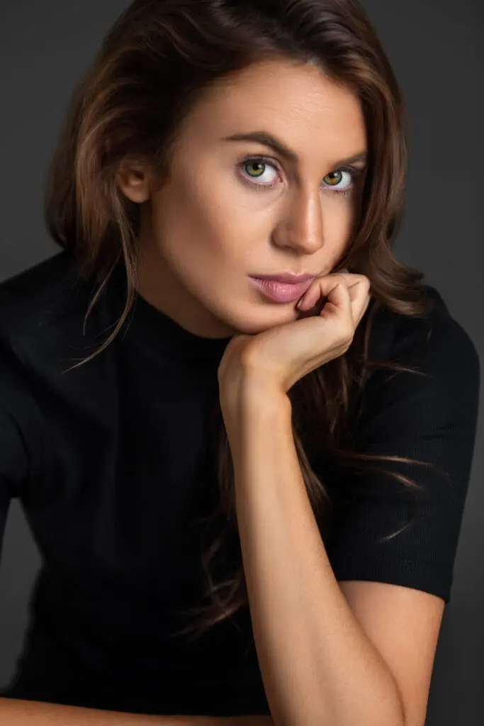 Rebecca seated in a black shirt for a natural-confidence studio portrait