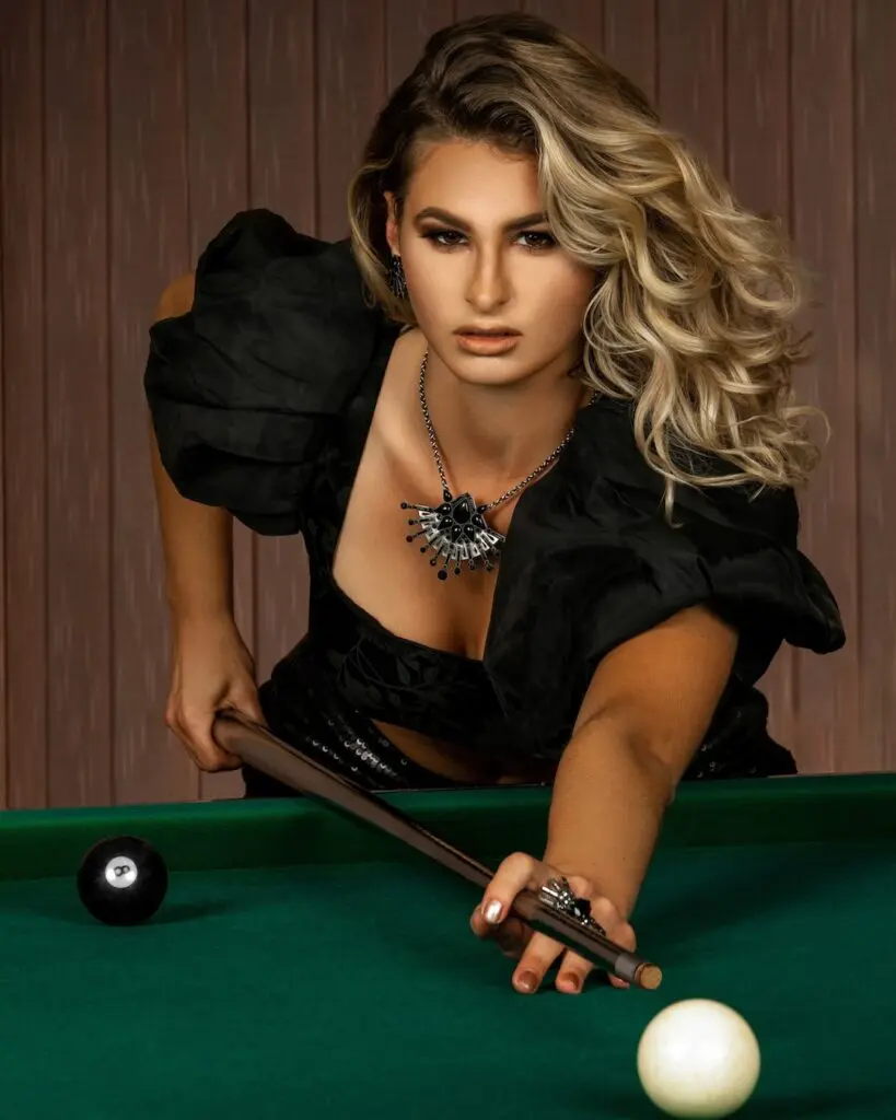 Blonde model in black playing billiards in a fashion editorial