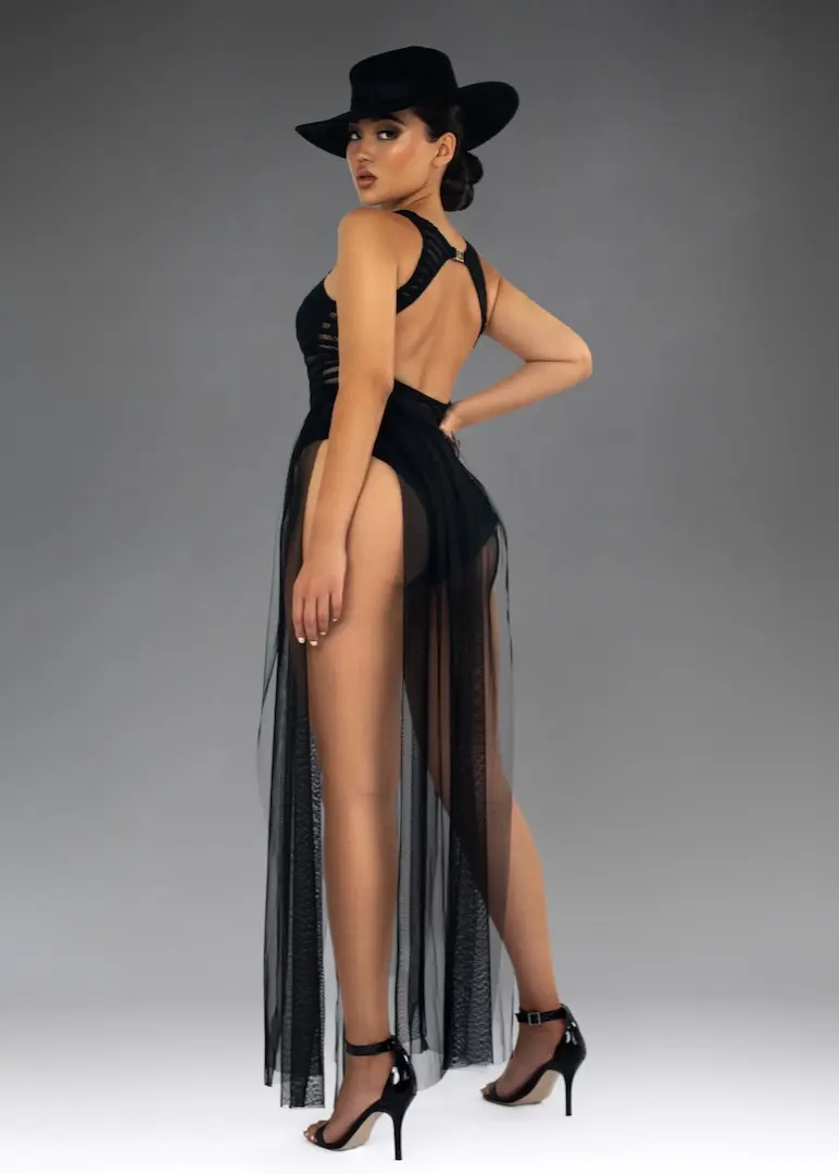 Confident Asian woman standing in a black bodysuit and heels during a fashion editorial
