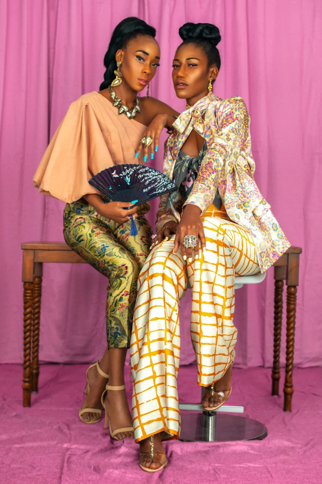 Close portrait of Vanessa and Claudine wearing satin looks and colorful statement jewelry.