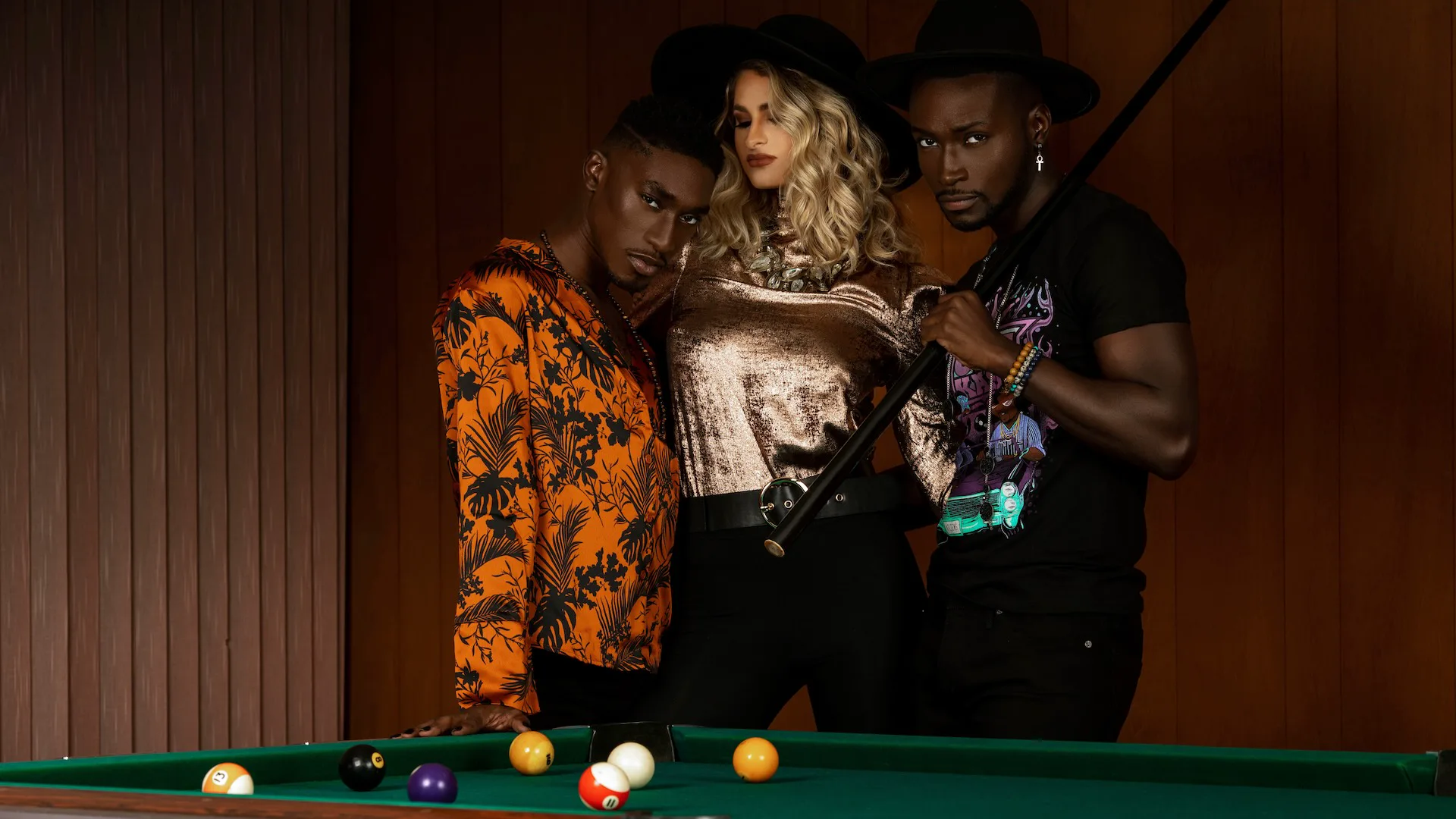 Friends talking and relaxing together around a pool table