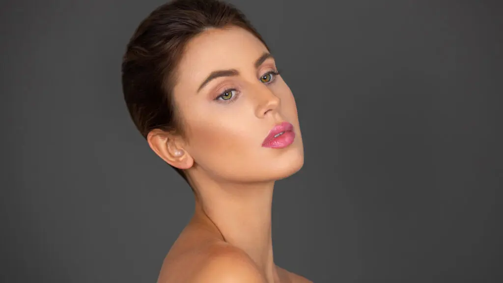 Soft-glam beauty headshot of Rebecca with natural makeup and an elegant updo