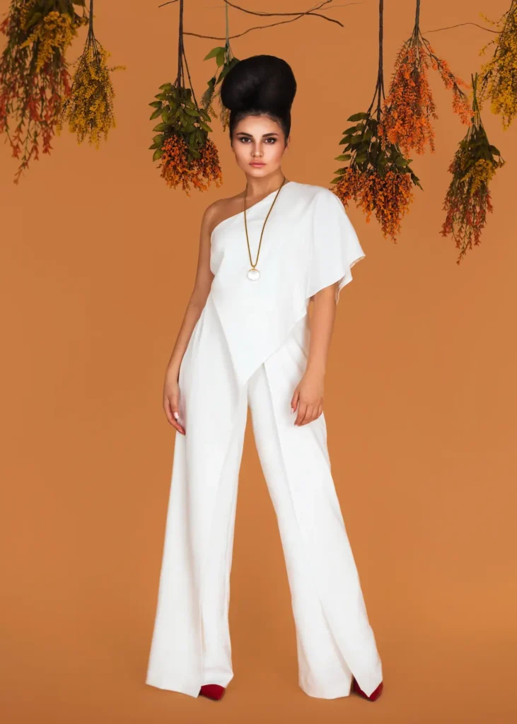 Mariana standing with her hands in the pockets of a wide-leg white jumpsuit