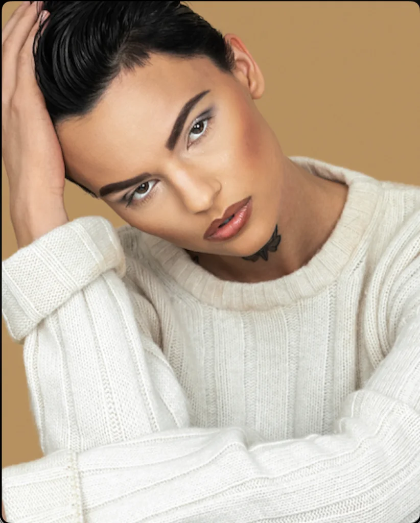 Model in a cream ribbed knit sweater with short swept-back dark hair