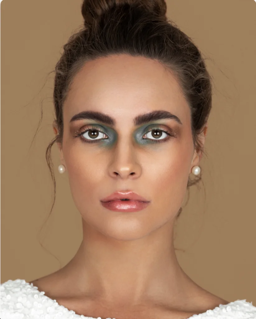 Woman with a high bun and metallic silver eye makeup